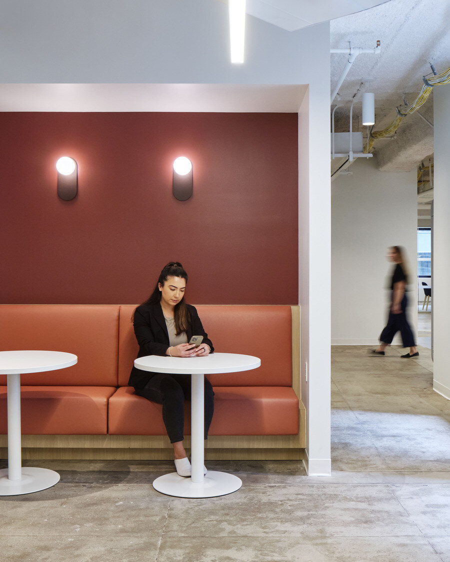 employee using phone sitting at booth